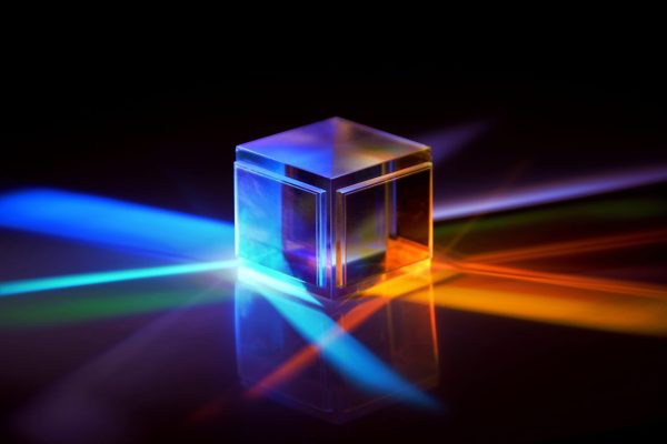 multicolored rays of light reflected by a crystal cube